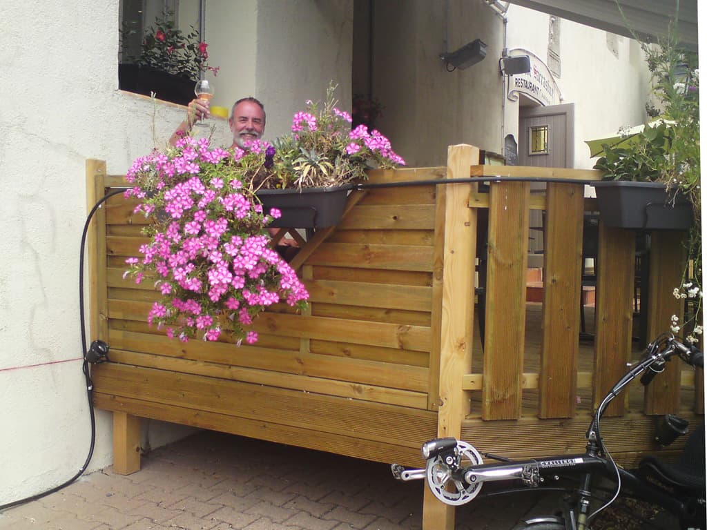 11.48am  The owner/chef came out to say hello and also to take my photo - bike, cascading hanging baskets of flowers and cheers to you.