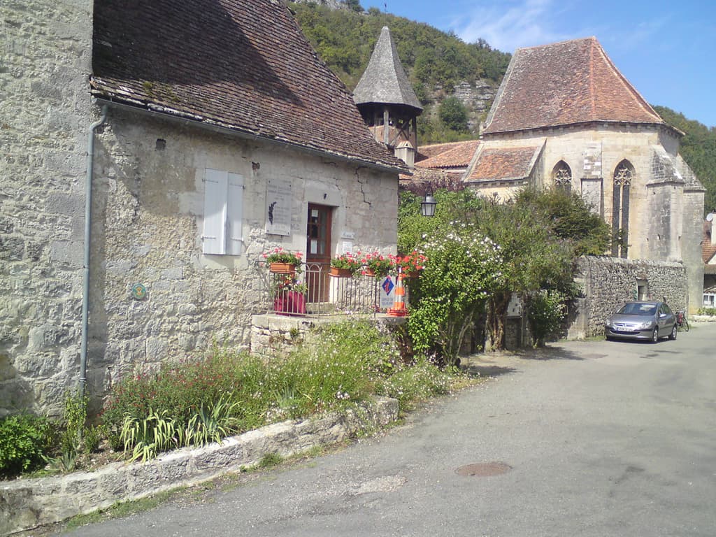 What a pretty little village, there was a museum, a gite d'Etape, a 12th Century Priory, and a church almost as old.  However, what first attracted our attention was the view through a half-closed door into a garden with a tree and a few tables underneath.  A place for lunch.