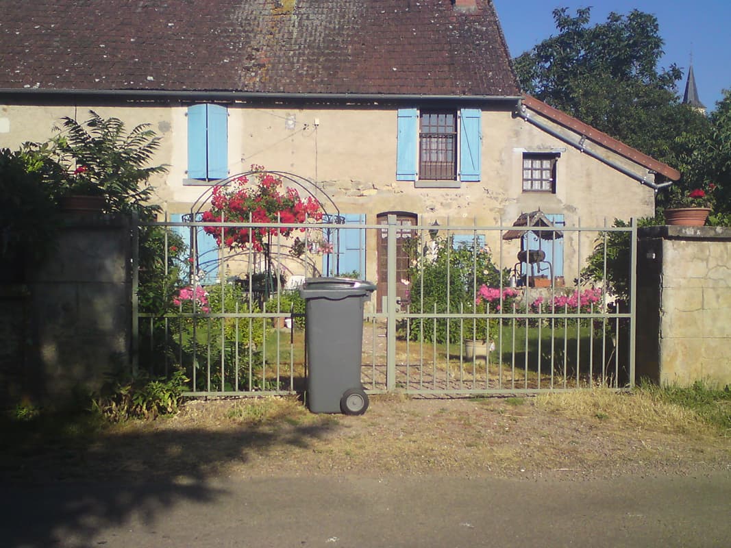 <p>I've a few photos of houses with painted shutters and flowery front gardens.&nbsp; Notice the small well housing and the church steeple in the background, more obvious if you click on the photo to see the bigger version.</p>