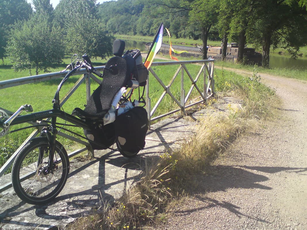 <p>There seemed to be times when the canal just didn't go through any towns with shops.&nbsp; I'd taken two detours into villages looking for food
 with no luck at all and in the end took a longer detour to Corbigny.&nbsp; Quite a hilly detour in fact, I was already spoiled
 with the easy flat riding along the canal.</p><p>At Corbigny I found food, including what was to become my favourite: pat&eacute; de t&ecirc;te, I also bumped into the couple I'd got off the bus with at Auxerre.&nbsp; They were going to follow the Vezelay pilgrim route south to Lourdes.&nbsp; Unfortunately, they'd had a bad start in that the woman had fallen off her bike on the first day and badly grazed her leg and arm, but she was carrying gamely on.</p><p>This photos is after I've had a fast descent back to the canal, easily found on tiny side roads thanks to the Memory Map GPS.&nbsp; You can alway's tell when I've food onboard, the back rackpack has it's lid extension raised</p><p><img title="Smile" src="../scripts/tiny_mce/plugins/emotions/img/smiley-smile.gif" border="0" alt="Smile" /></p>