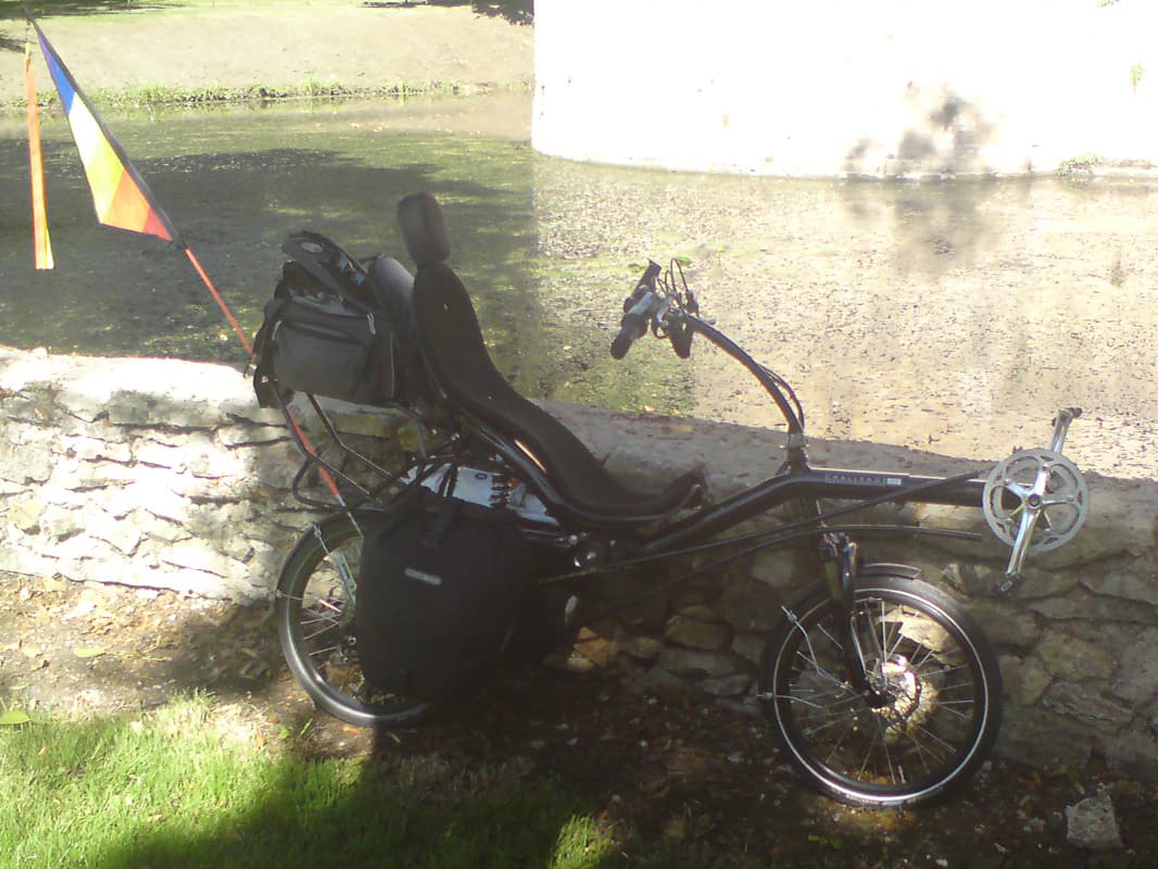 <p>I peddled around the back to the chateau and had my third breakfast, fruit and bread, sitting on this wall next to the moat.&nbsp; If you roll your mouse over this image you'll see up a bit and the tower that you can only see the foot of in this picture.</p>