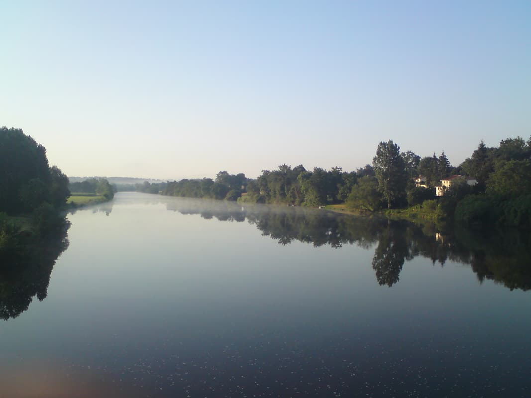 <p>This was the view from the other side of the bridge, looking south.&nbsp; It's early and so you can still see a bit of mist over the river, which is like a mirror, not a ripple.</p><p>I bought my provisions and decided to explore the village a little.&nbsp; I made my way up to the church on the hill, thinking I'd find a town square
 with a bar or somesuch, but there was nothing.&nbsp; I did, however, have the good fortune to meet someone coming out of the church and got into a most interesting conversation about the meaning of life, the changes in village life, and his job, having come out of retirement to do it, of training vets.</p>