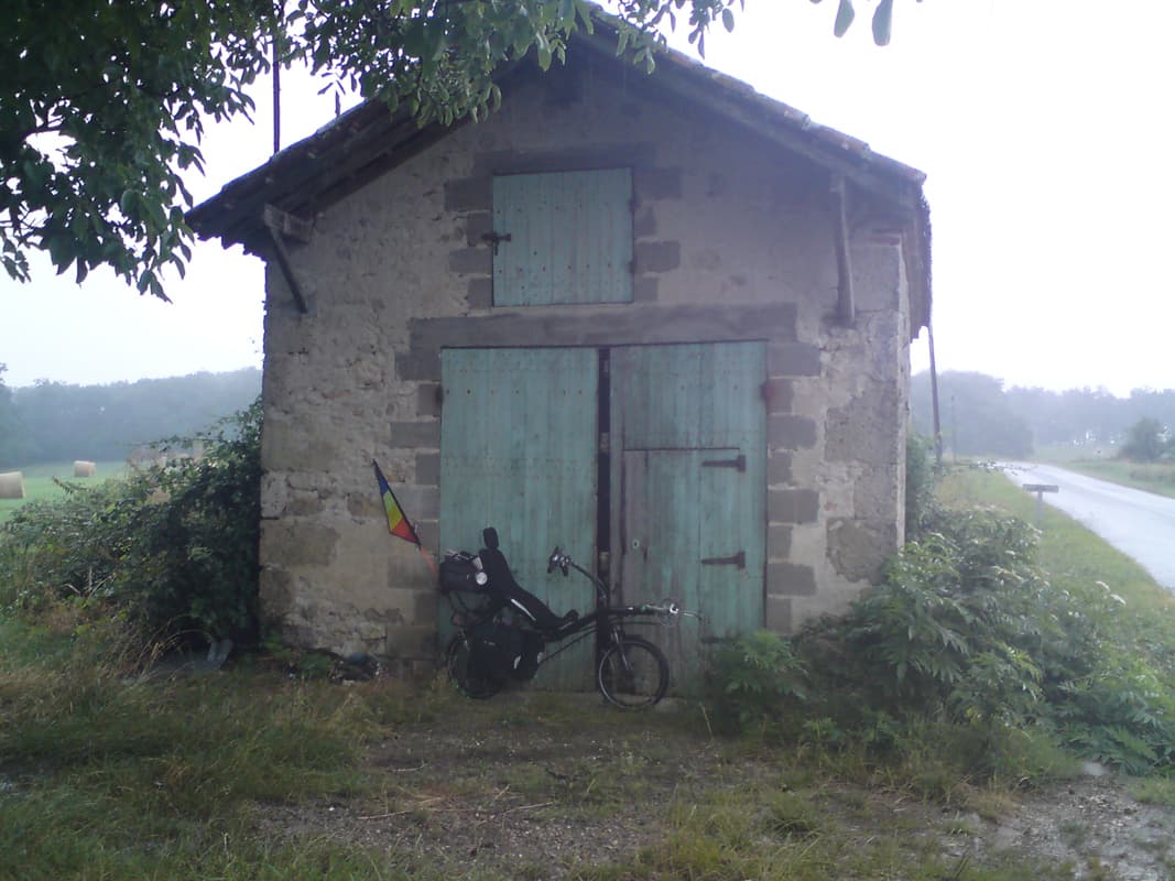 <p>The rain had been constant, but not too heavy, but then it really turned nasty and I had to look for shelter.&nbsp; I don't quite know why since I was already soaked to my underpants, but then it's alway's nice to be under the dry eaves of some building looking out at the rain, rather than the other way around.</p><p>I stayed here for half an hour and finished off the last of my cherries before the rain eased and I set off again down hill for a change.</p>