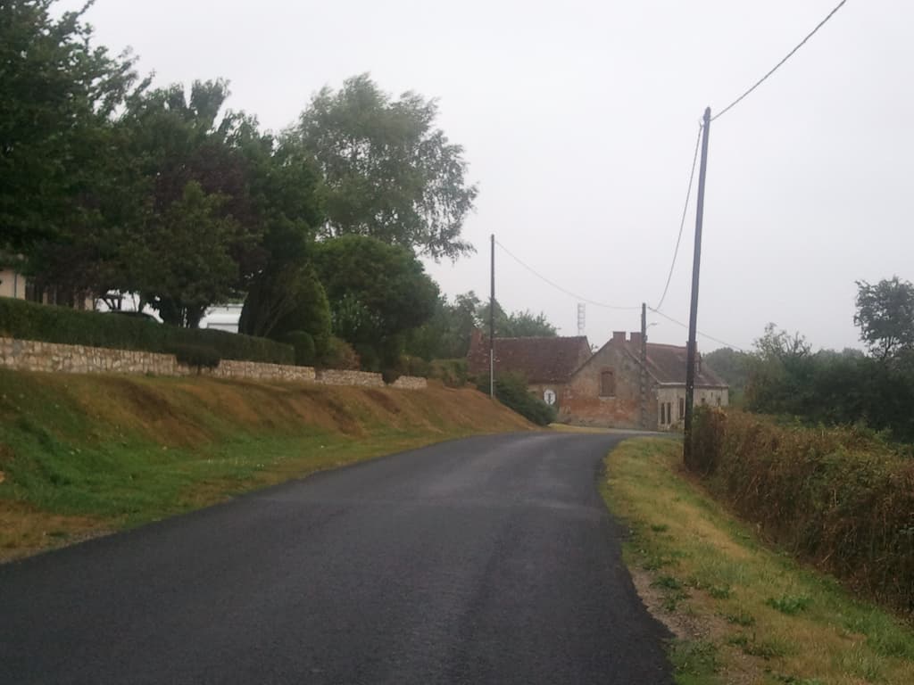 <p>Not sure why I took this: the small humbly-crumbly cottage at the end, the perfect tarmac, or the high hedge through which one can't see but a dog still knew I was there and was barking at me.</p><p>My entire journey through France had a soundtrack of barking dogs. &nbsp;Whether they could see me or not they'd start barking at one end of the fence and chase along barking until the other end. &nbsp;Sometimes the high soprano of small dogs, sometimes the deep bass of dogs as big as pit-ponies. &nbsp;I figured all of them were more or less saying the same thing: 'come here and I'll eat you'. &nbsp;Except in French.</p><p>Luckily, for the most part, though not entirely, they were all behind fences. &nbsp;Also luckily, the few that were roaming free I managed to out-run.</p>