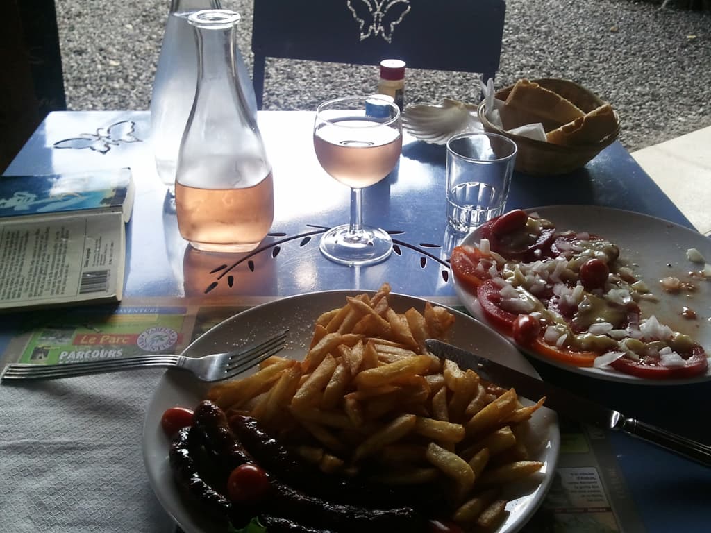 <p>It's not a large campsite but a very nice one, and the best thing about it is they do food, pizza's done in a wood fired oven and various other tasty things.</p><p>I was very tired when I finally got there and asked if I could go and pitch my tent before doing the paperwork, the woman said "no", she was in the middle of checking in two german hikers, but the man took pity and took me to a nice, quiet, shady spot. &nbsp;I got talking to the two hikers later, they were walking from Gibralter back to Germany, a reasonable stroll.</p><p>Actually, I was so tired, that after having a shower and washing my clothes, alway's the first thing to be done once the tents up, simply so that the washing will dry before bedtime, I went to buy a coke. &nbsp;I could use the sugar hit. &nbsp;Unfortunately, since both cans were red, I ended up with a can of Kronenberg!</p><p>However, the best thing about this site is the food, and I think I had this year exactly what I had two years ago; and enjoyed it just as much: a tomato and onion salad (with tomatoes picked that morning with sweet Cevenne onions), followed by meguez and chips, with a petit pichet of ros&eacute;.</p><p>If you mouse over this photo you can see the 'restaurant' and if you click you can get a larger picture of the mouthwateringly tasty food.</p>