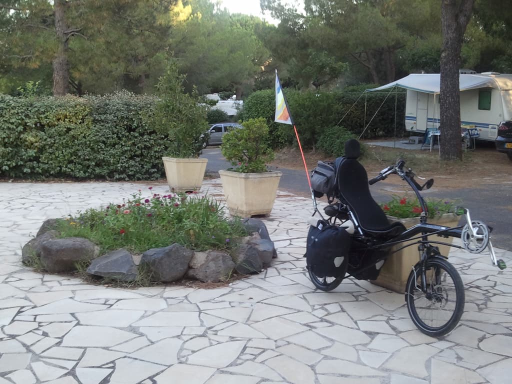 <p>It's a municipal site and very nice, though only about 30 places. &nbsp;There was no guardian but a sign on the door said to just set up, which I did. &nbsp;I showered and did my washing and got that out to dry too. &nbsp;It was very warm so I set up my campseat (made from my thermarest) and started to read my book.</p><p>Just then a car arrived with a couple and a child from Paris who said they'd reserved that place after phoning the site. &nbsp;I was definitely not wanting to move. &nbsp;How, if there's no guardian on the site, no sign indicating a reservation can that possible be? &nbsp;A sy'stem of secret reservations? &nbsp;So, selfishly perhaps, I just stayed put, though I did offer to share the pitch, and after a while the couple went off somewhere else.</p><p>The guardian, who arrived at 6.00, remembered me from two years ago, happily charged my bits and pieces, gps and powermonkey that is to say, while I went off to buy some olives and odds and ends for dinner.</p><p>In order to spead the load I'd left my phone on charge with an english couple in a caravan who kindly gave me a beer to have with my olives, cold too. &nbsp;I tried to reciprocate by offering olives but they didn't like olives apparently.</p><p>Met quite a few other people too, a dutch guy whose electric window was broken and needed to know how to say that in french, and the couple next to me who had done some cycling in the past and wanted to know about the recumbent. &nbsp;All in all a very friendly site.</p>